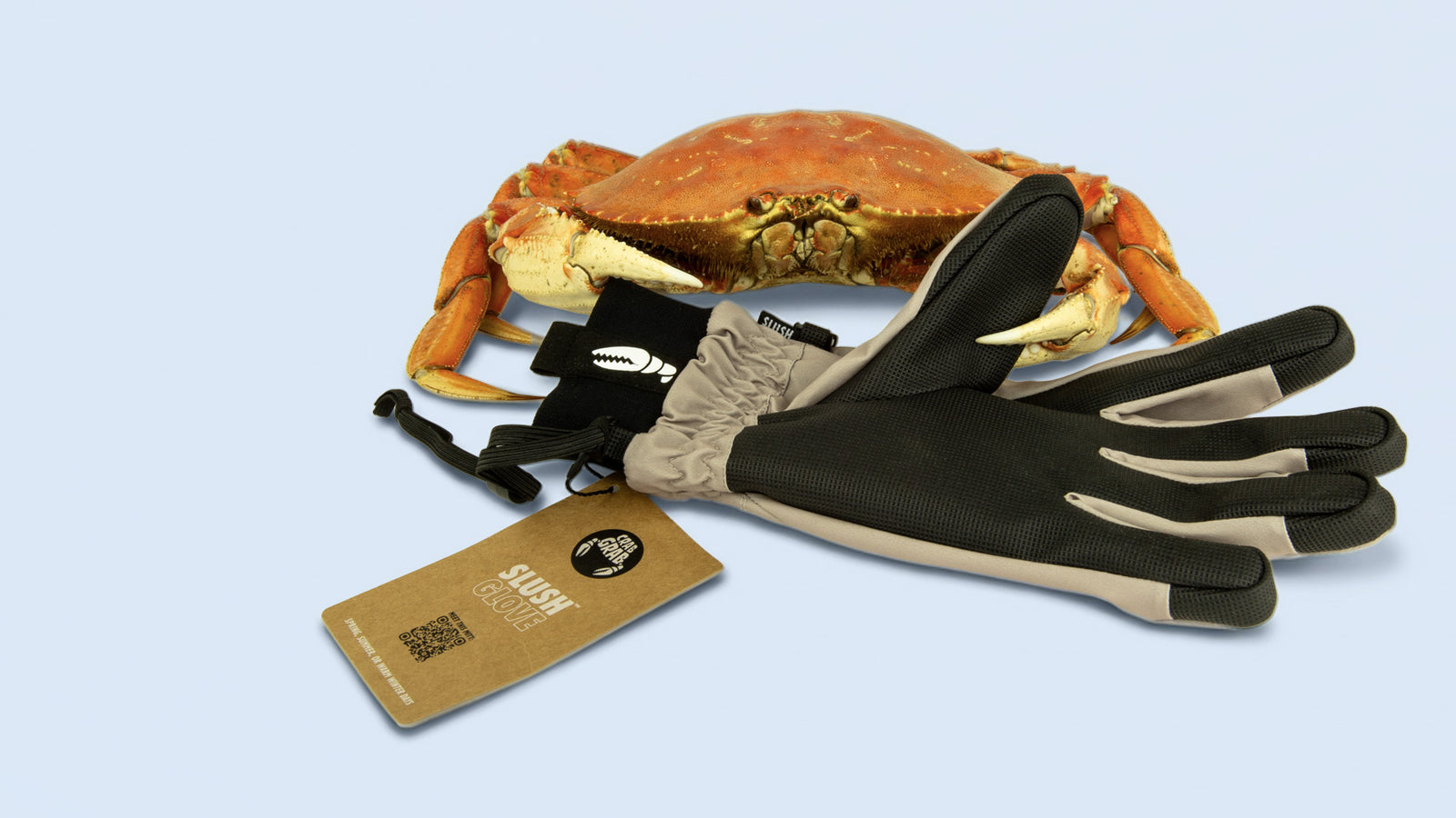 Khaki pair of the Slush gloves, a spring weight snowboard glove by Crab Grab, pinched by a real crab.